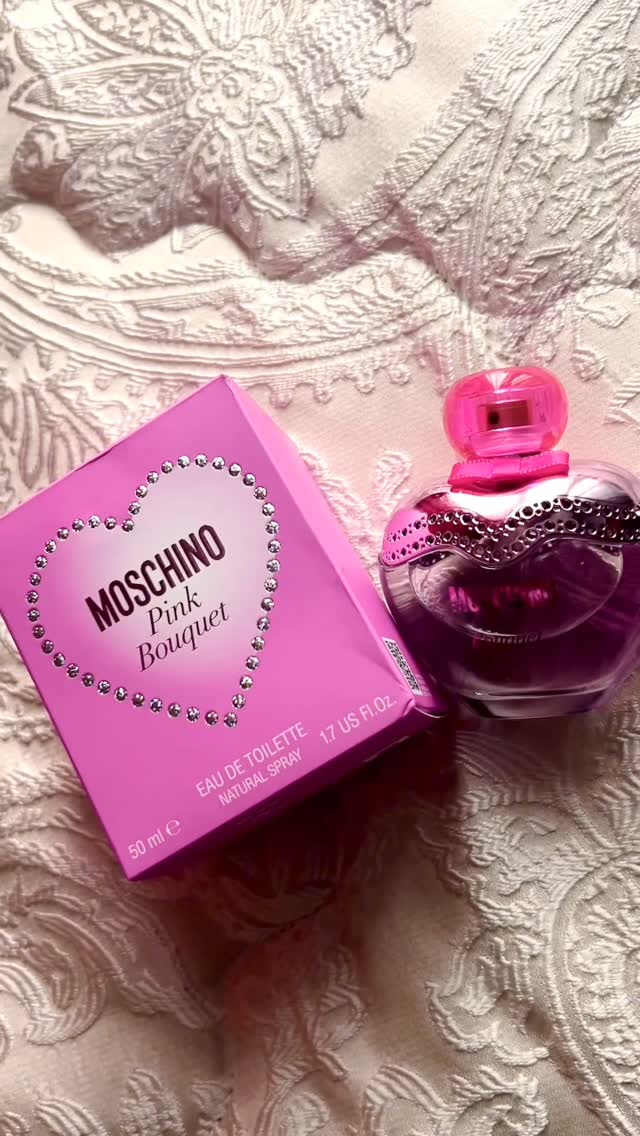 Moschino Pink Bouquet fragrance bottle and box on embroidered fabric