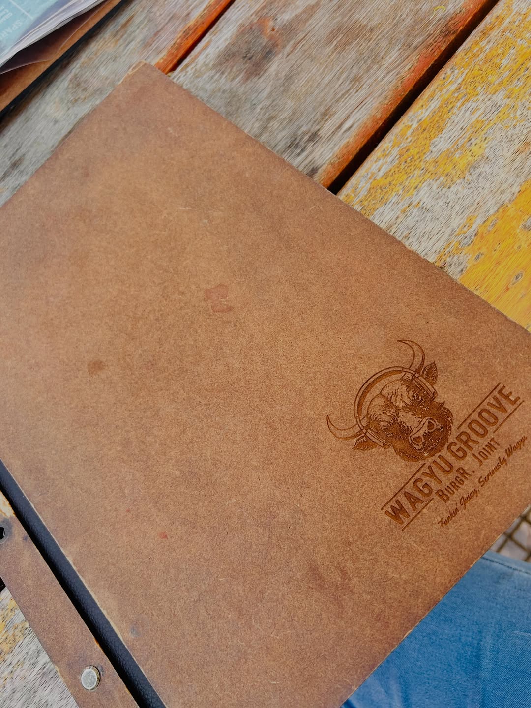 Wagyu Groove Burger Joint menu on a weathered wooden table